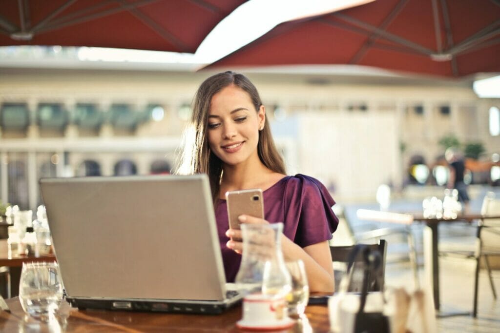 Mujer creando menú para restaurante en computadora y celular